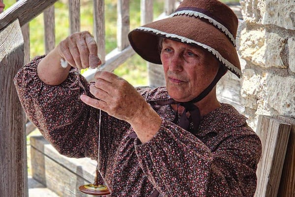 A volunteer shows off her thread spinning skills at the Historic Anderson Mill